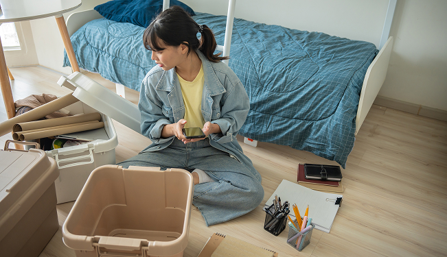 College student writing a budget in a notebook