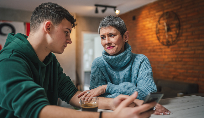 Student and parent having a conversation at a kitchen table